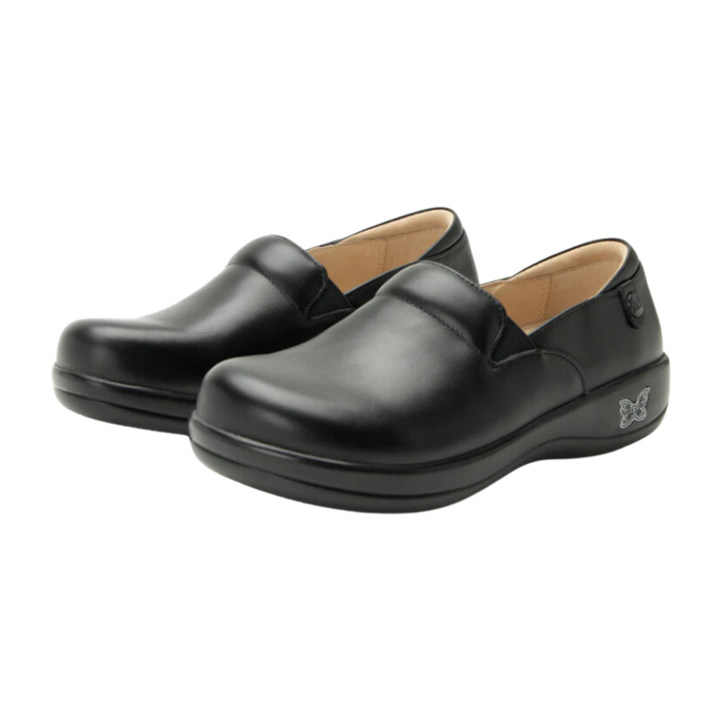 Alegria Women’s Keli Slip-On Shoe in Black Nappa side view showcasing the stain-resistant embossed leather upper, professional slip-on silhouette, padded collar, mild rocker sole, and slip-resistant outsole designed for lasting comfort and workplace stability.