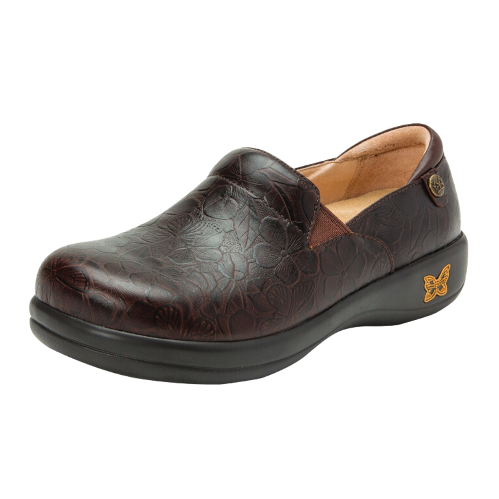 Alegria Women’s Keli Slip-On Shoe in Flutter Choco side view showcasing the stain-resistant leather upper with a rich brown luster finish, professional slip-on silhouette, padded collar, mild rocker sole, and slip-resistant outsole designed for lasting comfort and workplace stability.