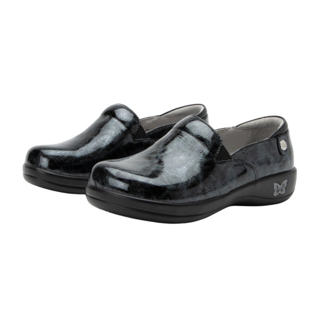 Alegria Women’s Keli Slip-On Shoe in Mantle side view showcasing the stain-resistant leather upper with a rich brown luster finish, professional slip-on silhouette, padded collar, mild rocker sole, and slip-resistant outsole designed for lasting comfort and workplace stability.