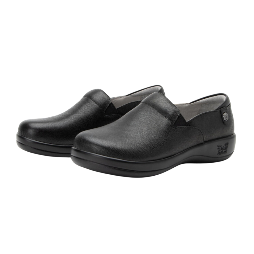 Alegria Women’s Keli Slip-On Shoe in Upgrade Black side view showcasing the stain-resistant embossed leather upper, professional slip-on silhouette, padded collar, mild rocker sole, and slip-resistant outsole designed for lasting comfort and workplace stability.