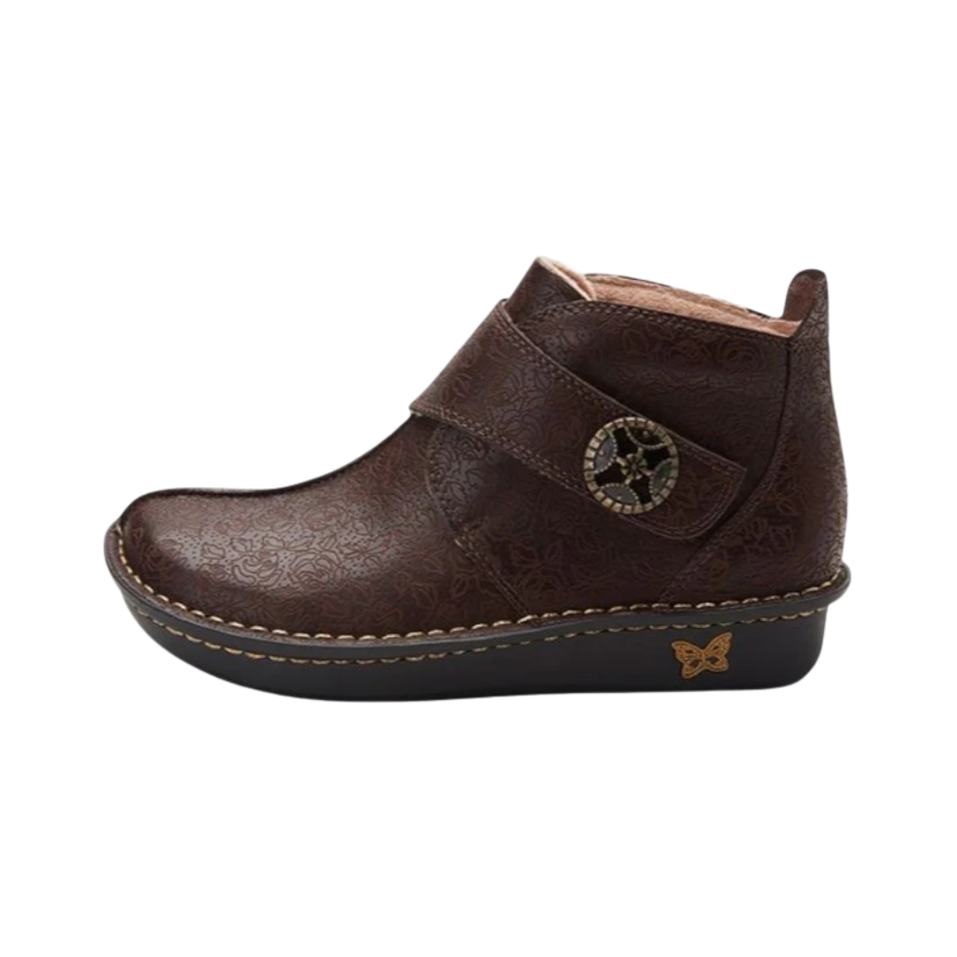 Alegria Women’s Caiti ankle boot in Cocoa Impression side view showcasing a premium leather upper, adjustable hook-and-loop strap, supportive ankle-height silhouette, and mild rocker slip-resistant outsole designed for stability, comfort, and all-day wear.
