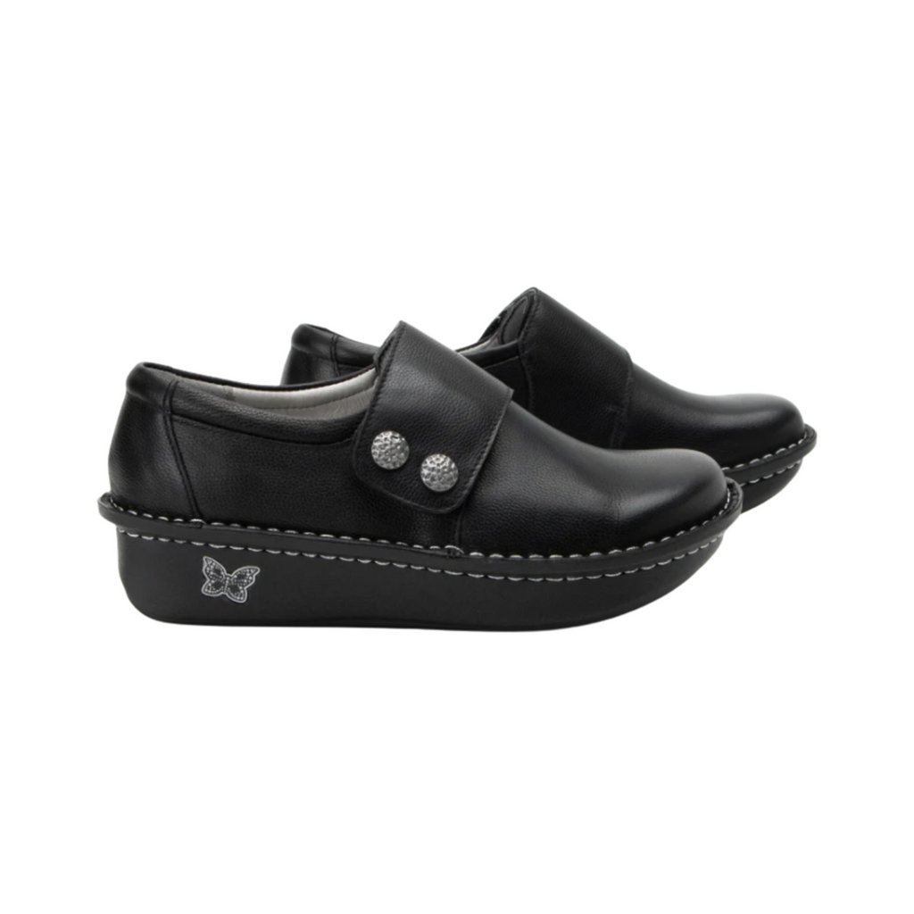 Alegria Women’s Deliah Slip-On Shoe in Upgrade Black side view showcasing the smooth leather upper, double elastic side gores, padded heel collar, mild rocker bottom, and slip-resistant outsole designed for professional style and all-day comfort.