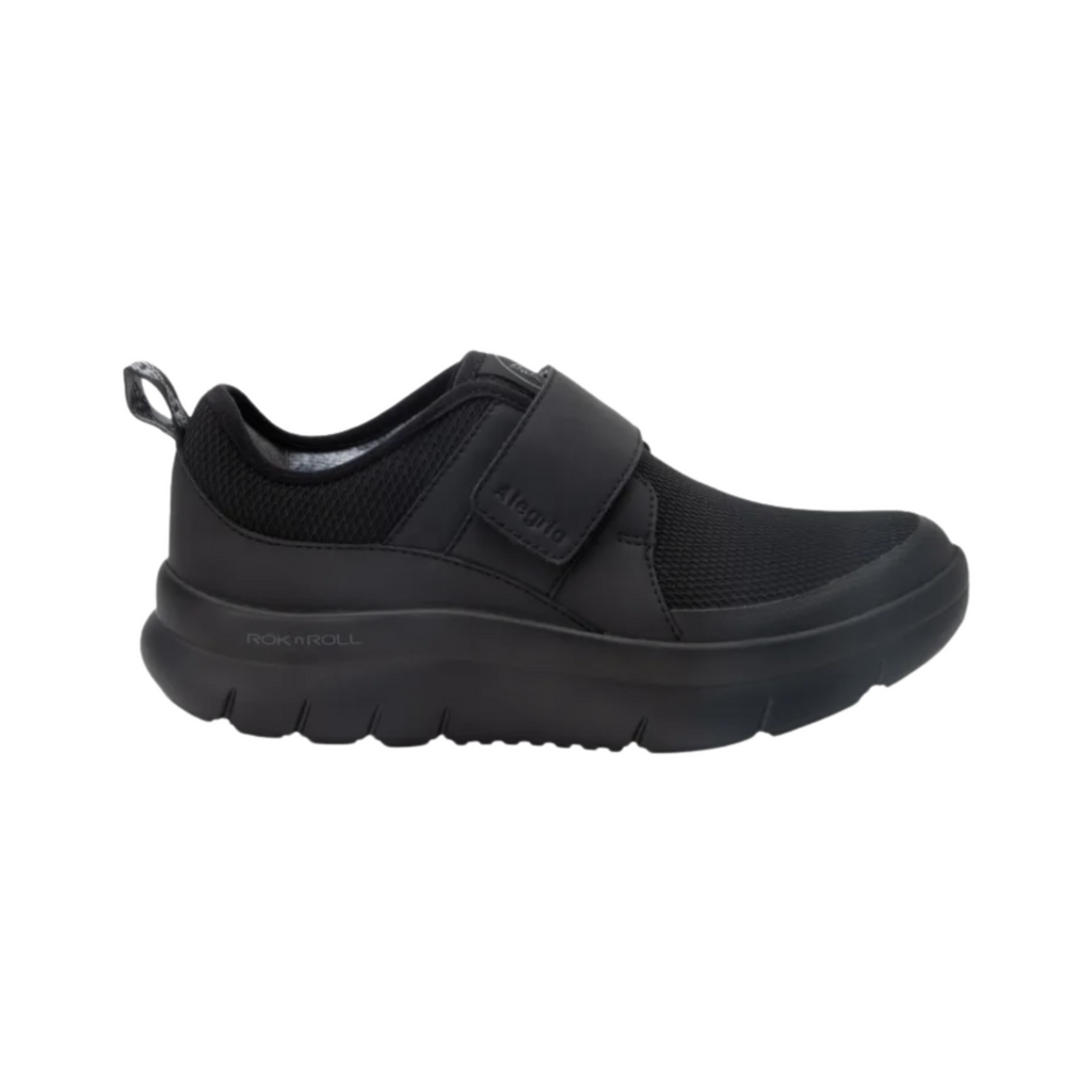 Alegria Women’s Double Trouble Slip-On in Black Mesh side view showcasing the breathable mesh upper, dual elastic gores, low-profile athleisure design, lightweight flexible outsole, and supportive Alegria comfort technology for all-day wear.