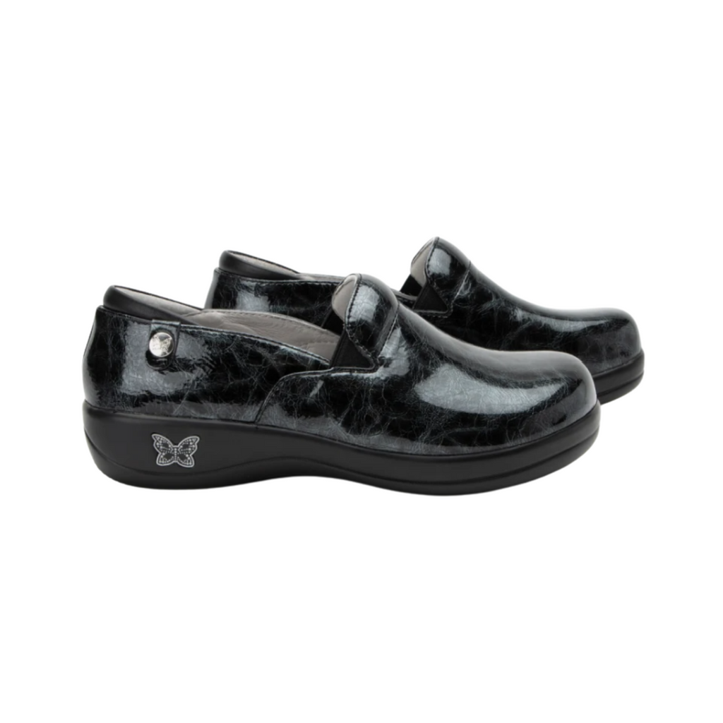 Alegria Women’s Keli Slip-On Shoe in Mantle side view showcasing the stain-resistant leather upper with a rich brown luster finish, professional slip-on silhouette, padded collar, mild rocker sole, and slip-resistant outsole designed for lasting comfort and workplace stability.
