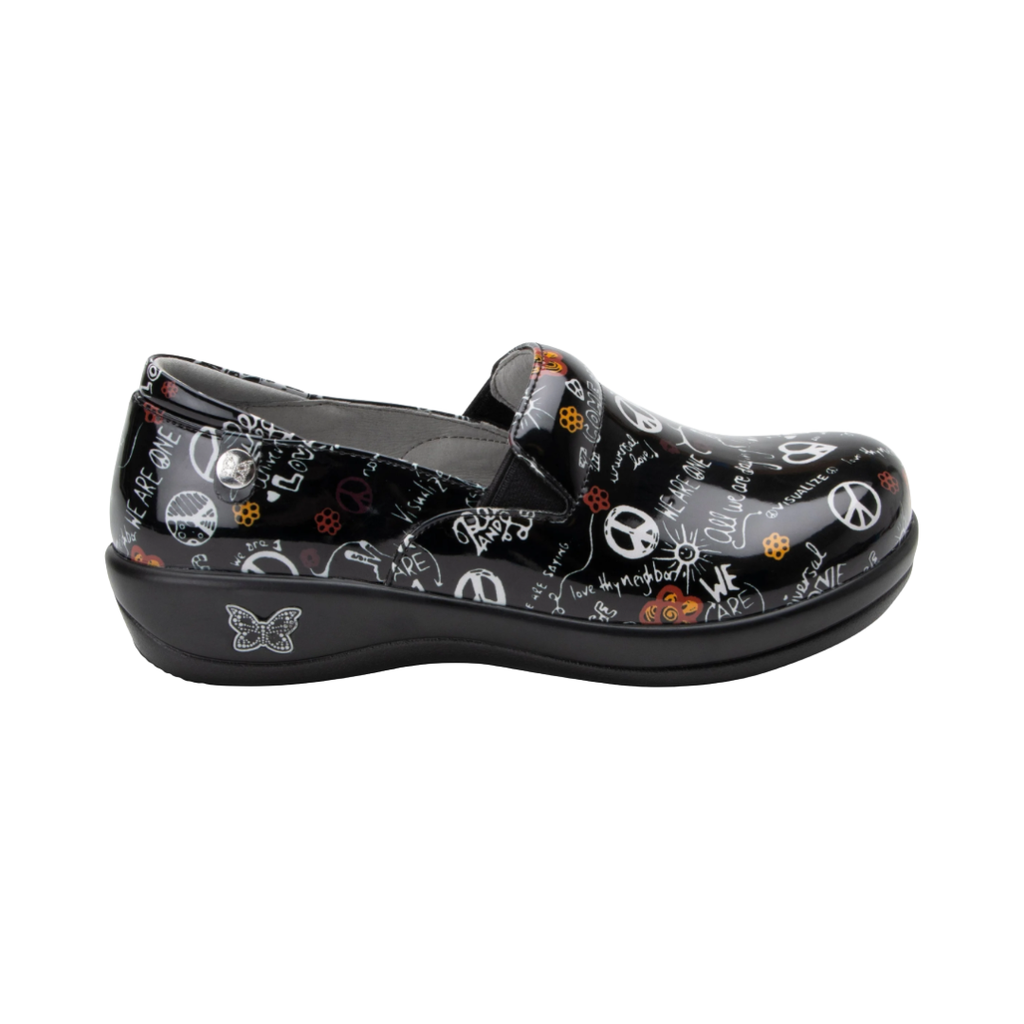 Alegria Women’s Keli Slip-On Shoe in Peace and Love side view showcasing the stain-resistant leather upper with a rich brown luster finish, professional slip-on silhouette, padded collar, mild rocker sole, and slip-resistant outsole designed for lasting comfort and workplace stability.