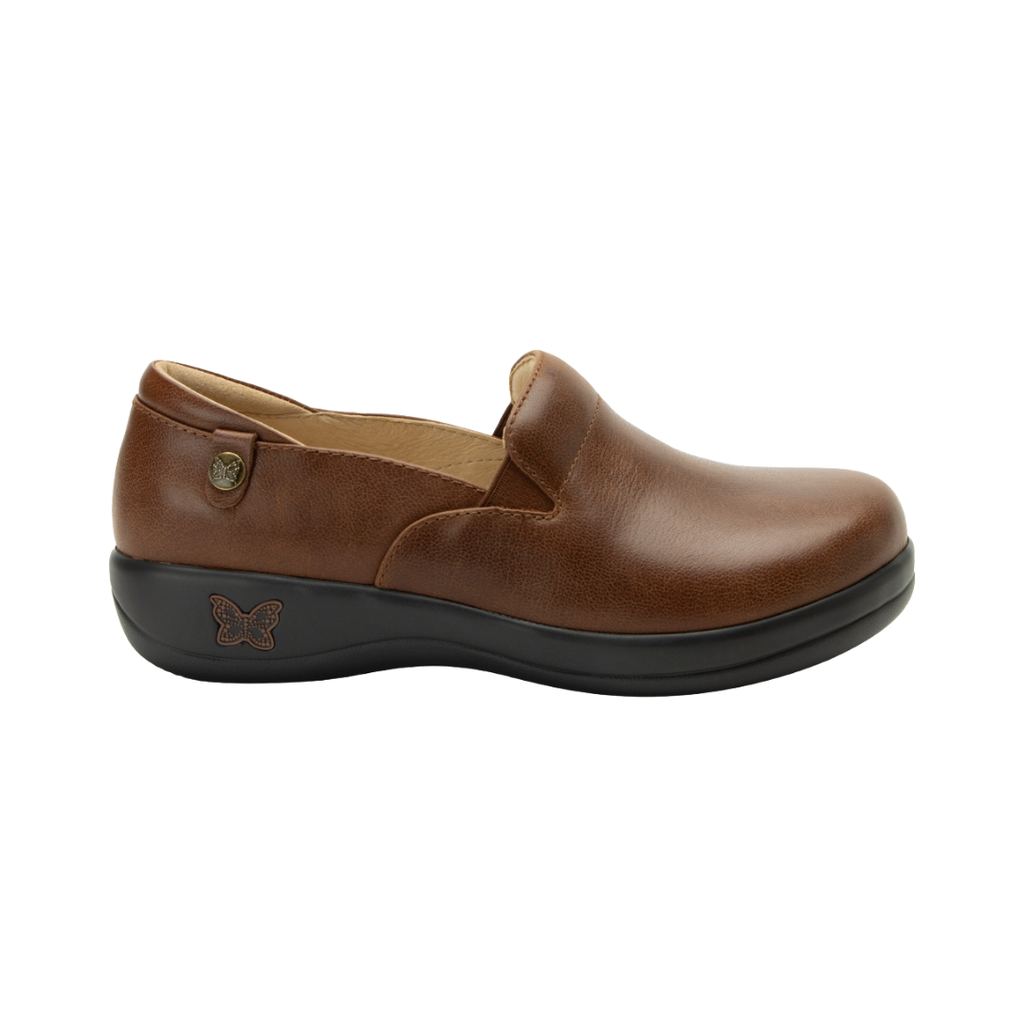 Alegria Women’s Keli Slip-On Shoe in Walnut side view showcasing the stain-resistant leather upper with a rich brown luster finish, professional slip-on silhouette, padded collar, mild rocker sole, and slip-resistant outsole designed for lasting comfort and workplace stability.