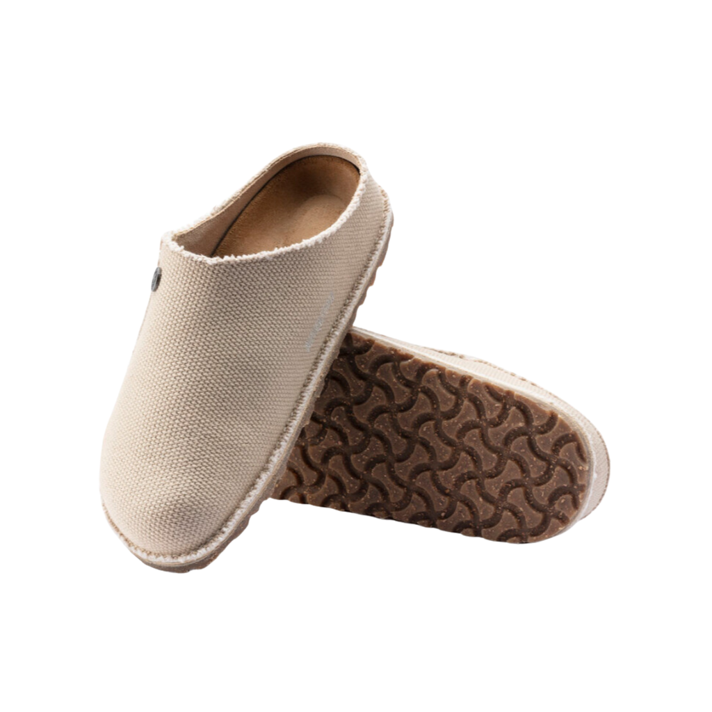Top and bottom view of the Birkenstock Women’s Zermatt Canvas Slipper in Eggshell Textile displaying the breathable textile upper, moisture-wicking interior lining, easy slip-on entry, anatomical cork-latex footbed with arch and heel support, and durable rubber outsole designed for traction, flexibility, and support for conditions such as plantar fasciitis, flat feet, high arches, arthritis, heel spurs, bunions, hammertoes, cold sensitivity, and general foot fatigue.