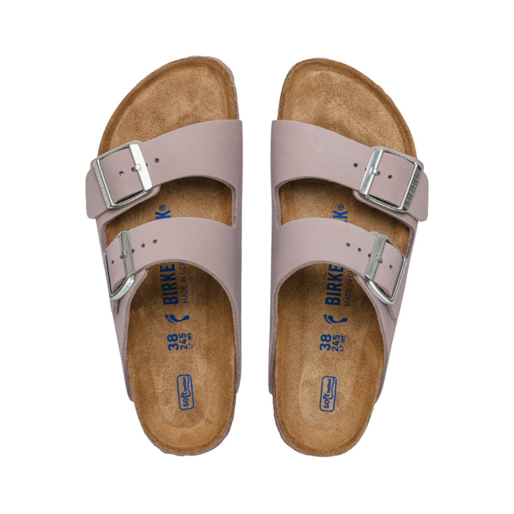 Top view of the Birkenstock Women’s Arizona Soft Footbed in Yomo Lilac Nubuck Leather displaying the premium nubuck leather upper, adjustable dual buckle straps, breathable suede footbed lining, anatomically shaped cork-latex Soft Footbed with arch and heel support, and lightweight EVA outsole designed for flexibility, traction, and support for conditions such as plantar fasciitis, flat feet, overpronation, metatarsalgia, heel spurs, arthritis, and general foot fatigue.
