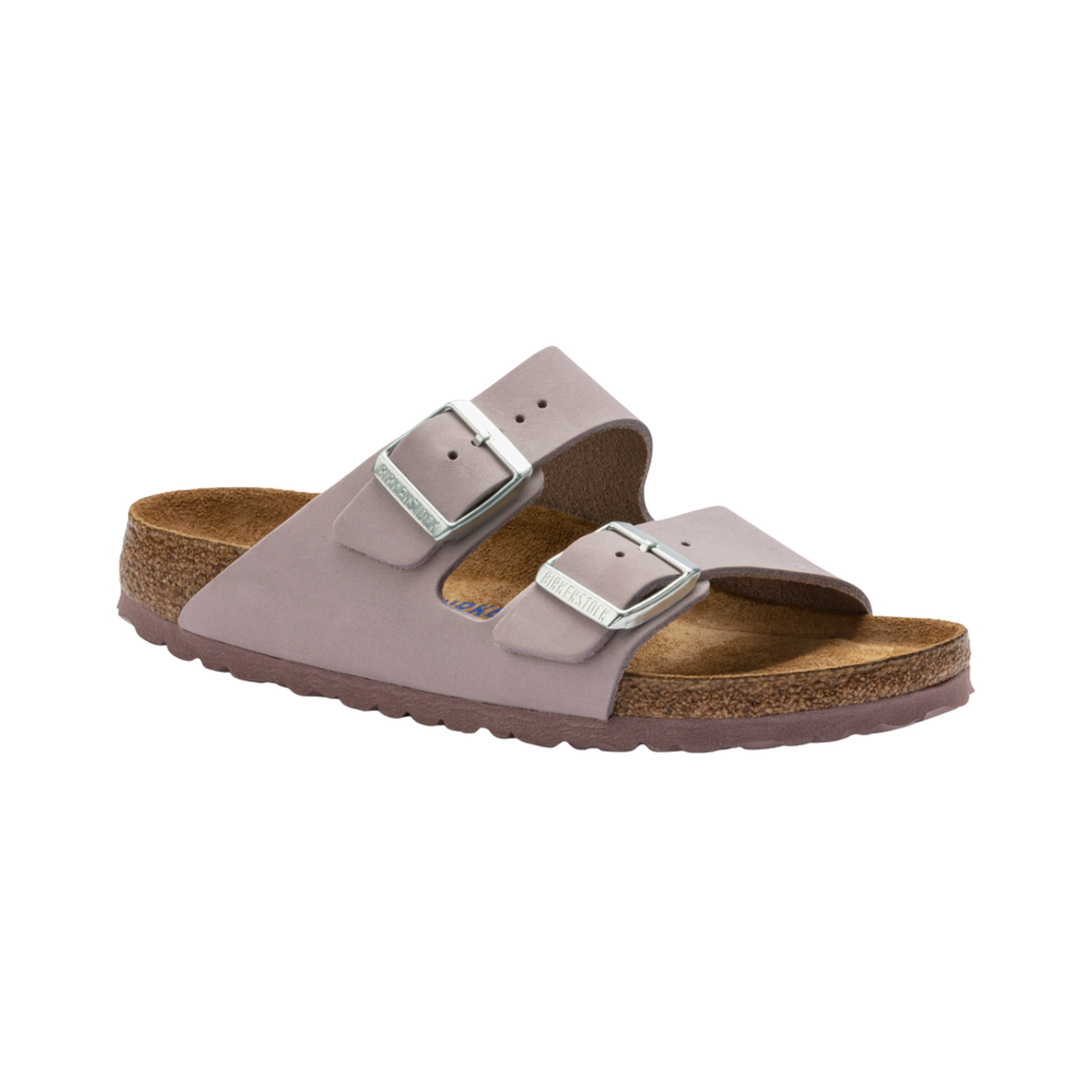 Birkenstock Women’s Arizona Soft Footbed in Yomo Lilac Nubuck Leather featuring a premium nubuck leather upper in a soft lavender tone, iconic dual-strap design with adjustable metal buckles, cushioned Soft Footbed with added foam layer, suede footbed lining, and lightweight EVA outsole designed for feminine style, everyday comfort, and reliable support.