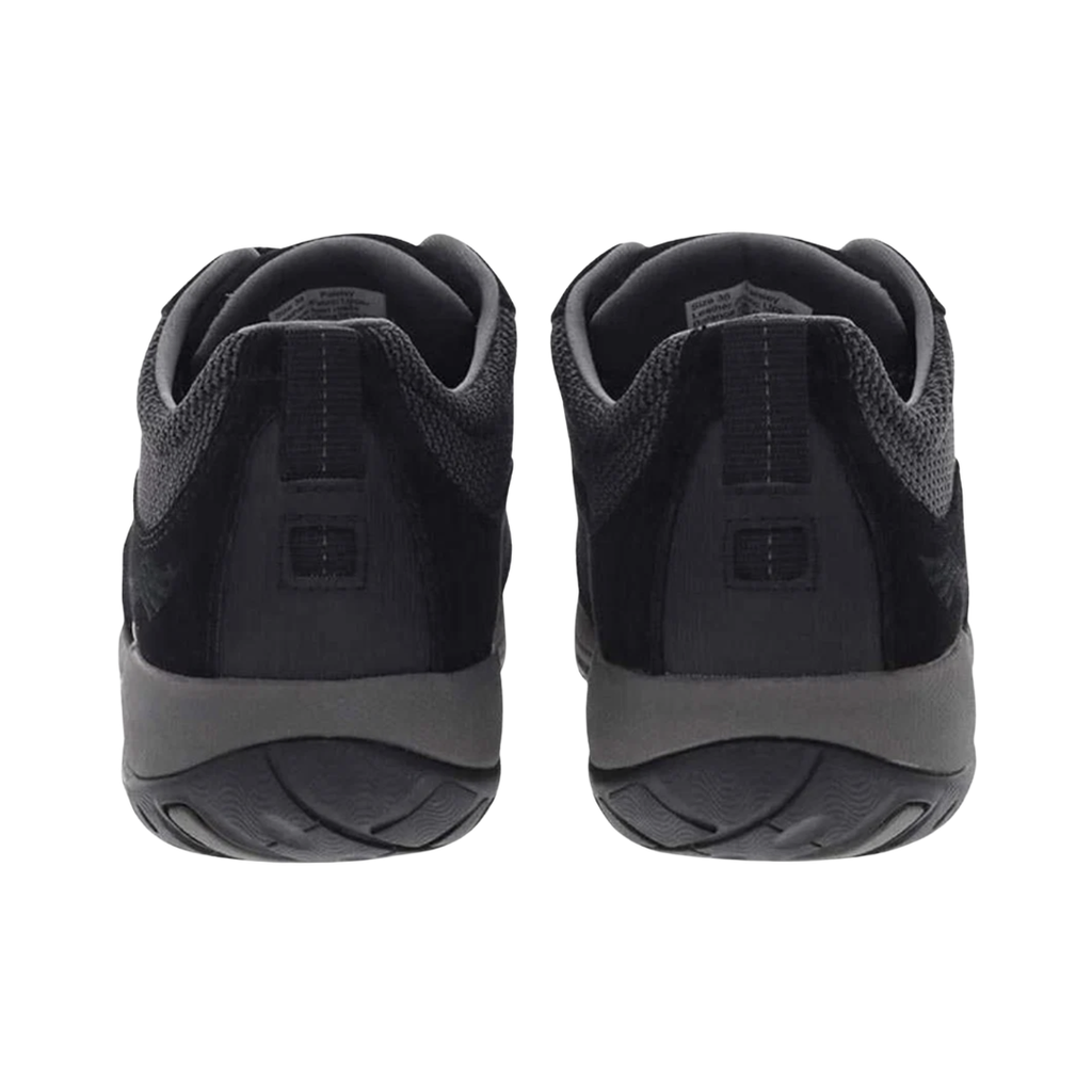 Back heel view of the Dansko Women’s Paisley Suede Shoe in Black highlighting the reinforced heel counter, supportive heel collar, TPU shank with Dansko Natural Arch® technology, shock-absorbing midsole, and durable Vibram® outsole designed to improve stability, reduce fatigue, and provide confident traction on varied terrain.