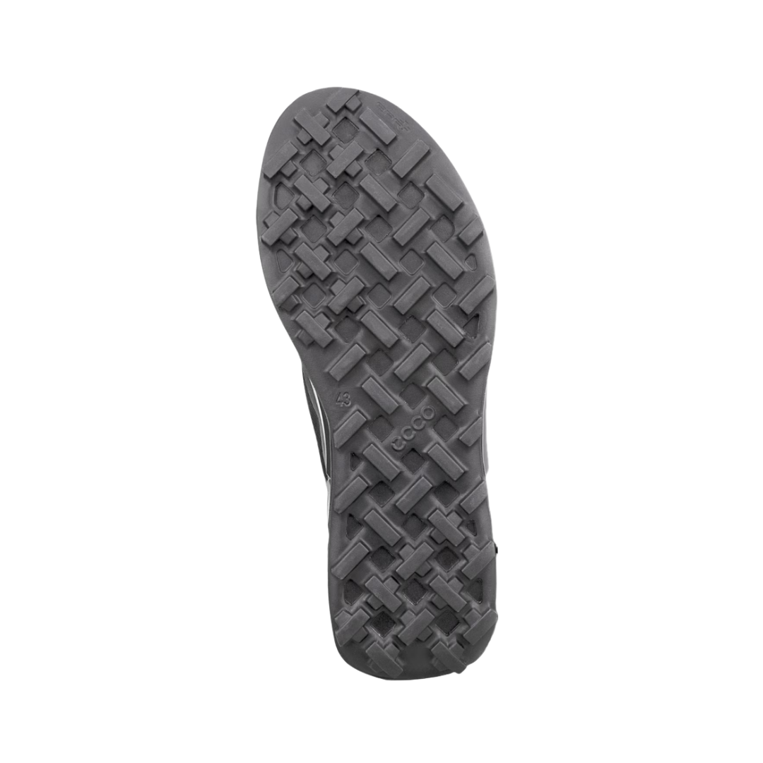 Bottom outsole view of the ECCO BIOM 2.1 X Country Low Hiking Shoe in Black/Magnet featuring the all-terrain rubber outsole with grippy tread designed to provide reliable traction on wet, dry, and uneven surfaces while ECCO BIOM® Natural Motion Technology and PHORENE™ cushioning help provide comfort for conditions such as plantar fasciitis, flat feet, overpronation, metatarsalgia, arthritis, joint pain, and general foot fatigue.