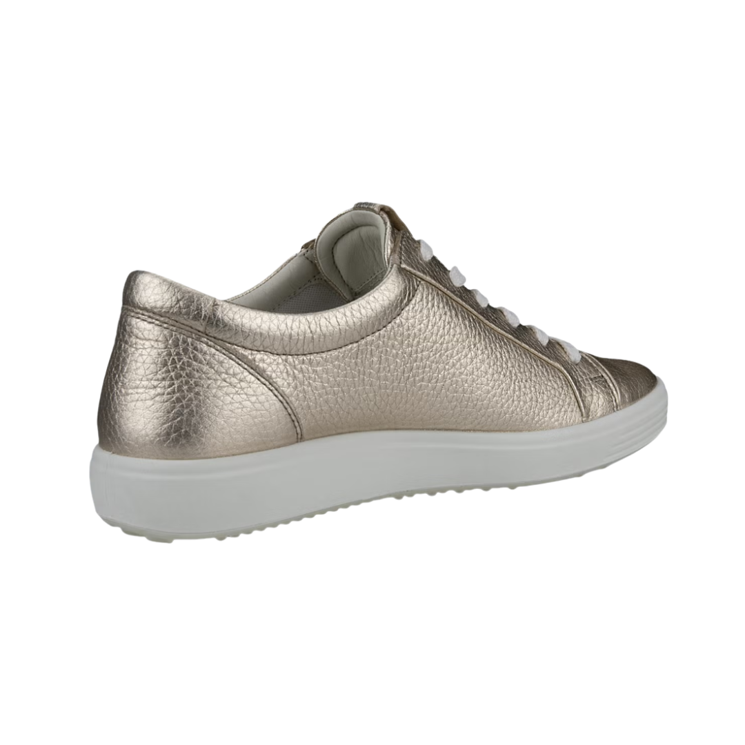 Back heel view of the ECCO Women’s Soft 7 Sneaker in Pure White Gold highlighting the supportive heel construction, soft textile lining, cushioned FLUIDFORM™ sole, and durable PU/TPU outsole designed to provide stability, flexibility, and shock absorption throughout the day.