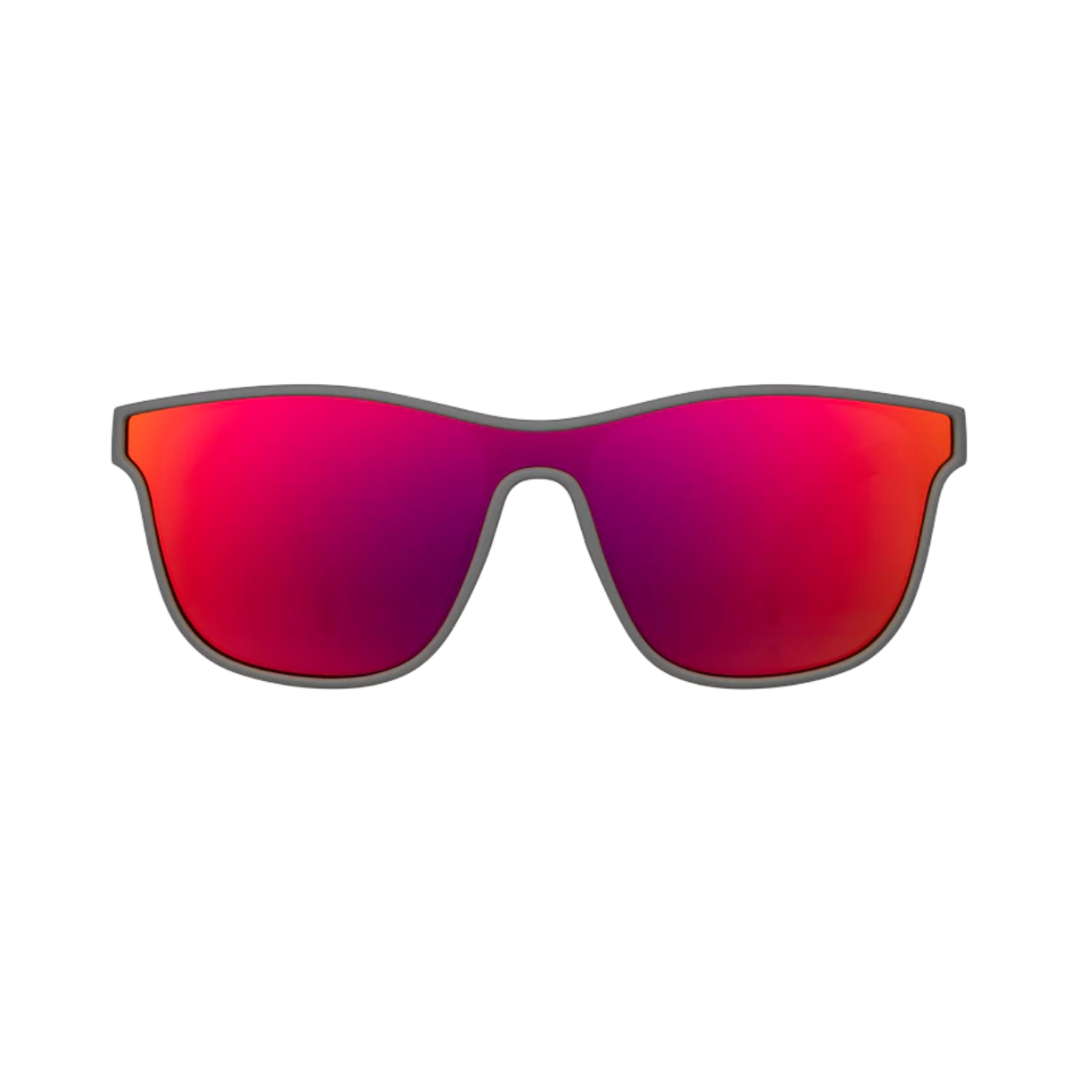 Front view of the Goodr VRG "Voight-Kampff Vision" sunglasses showcasing the streamlined wraparound silhouette, graphite frame, and reflective pink-red polarized lenses with UV400 protection for glare reduction and full UVA and UVB coverage.