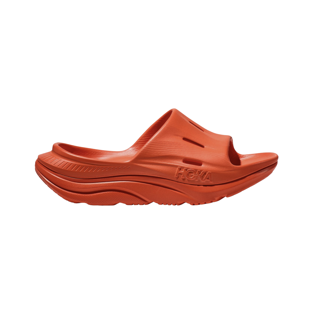 Unisex HOKA Ora Recovery Slide 3 in Orange featuring a dual-layer EVA midsole, injection-molded sugarcane EVA, Early-Stage Meta-Rocker™ geometry, and lightweight construction for cushioned post-workout recovery.