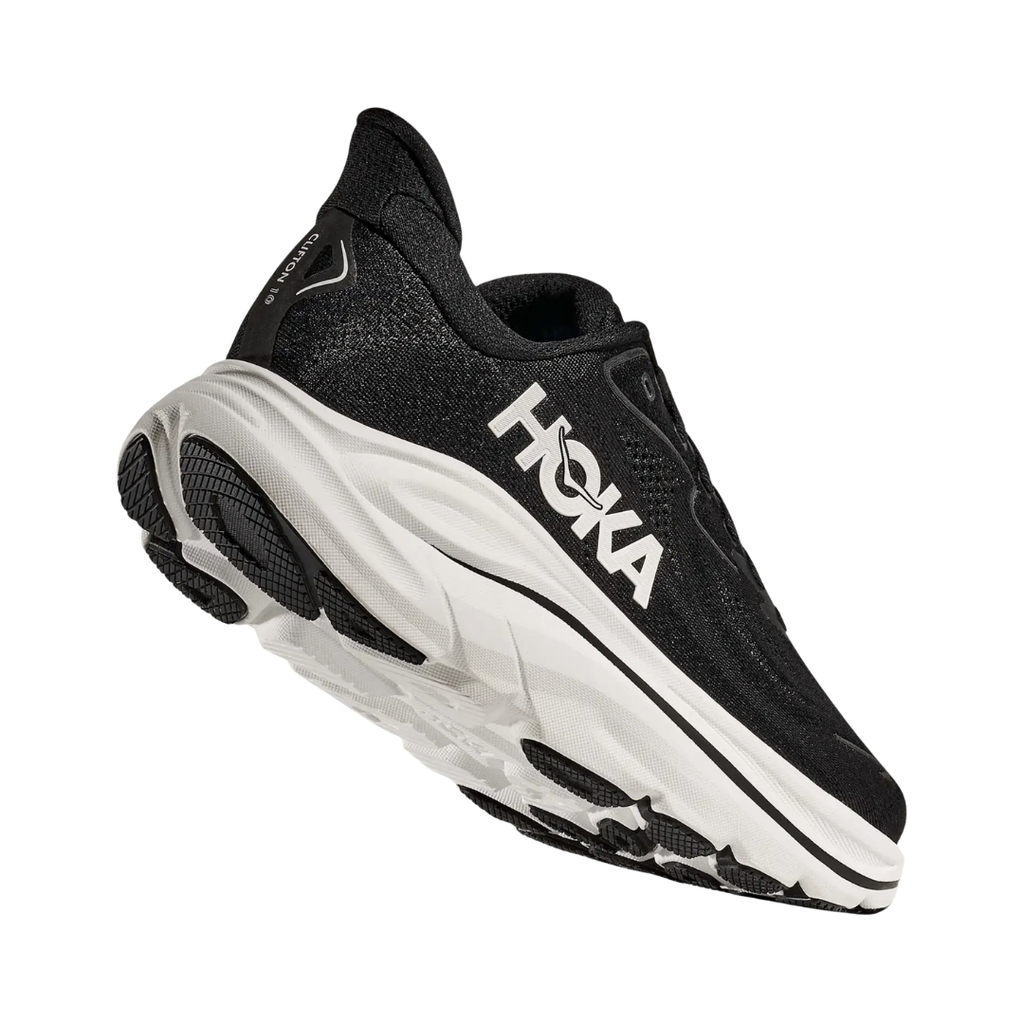 Bottom heel view of the HOKA Women’s Clifton 10 in Black/White, highlighting the durable outsole with traction zones designed for reliable grip and long-lasting performance.