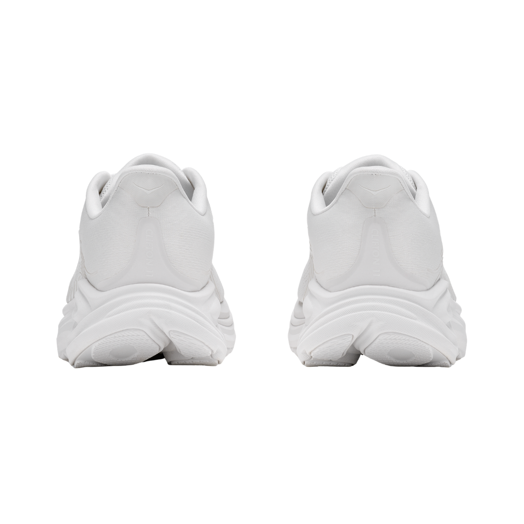 Rear view of the Women's HOKA Clifton 11 in White/White highlighting the cushioned heel, Rearfoot-Focused Active Foot Frame™, reflective details, and durable abrasion rubber outsole designed to provide stability and traction.