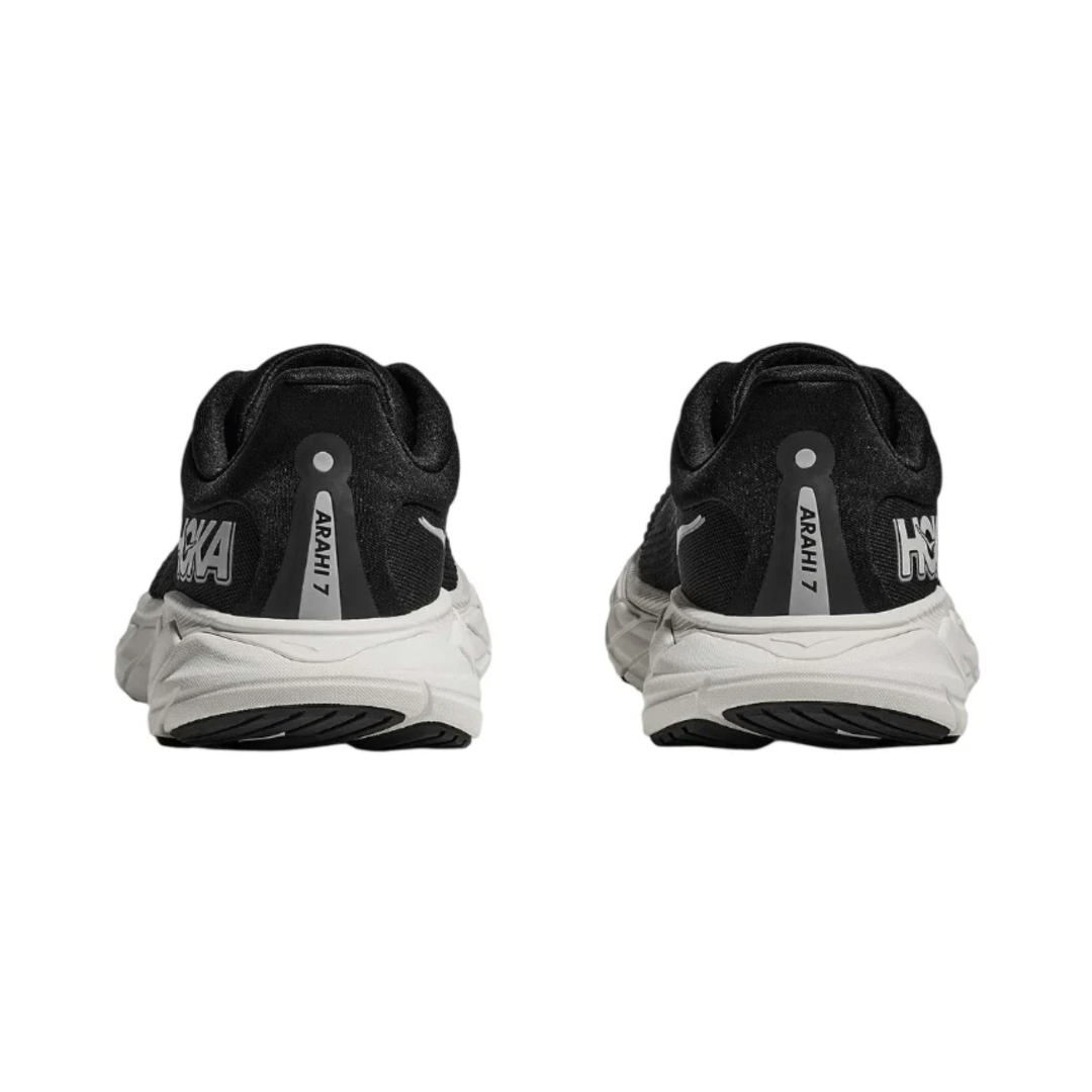 Rear view of the Women's HOKA Arahi 7 in Black/White highlighting the plush heel collar, J-Frame™ stability system, cushioned heel, and durable rubber outsole for reliable support and traction.