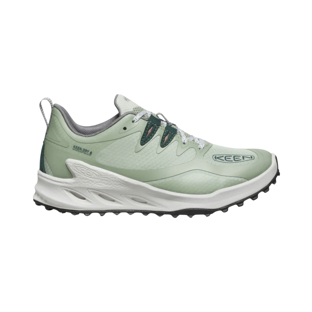 Side view of the KEEN Women's Zionic Waterproof Hiking Shoe in Desert Sage/Ember Glow, featuring a lightweight performance mesh upper, high-rebound EVA midsole, and rugged rubber outsole for trail-ready support.